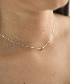 Modelo feminina jovem usando um colar bolinha