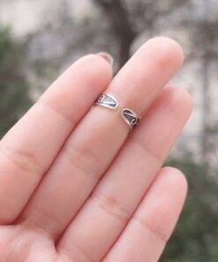 Mão esquerda feminina com verso de um anel bracelete de prata