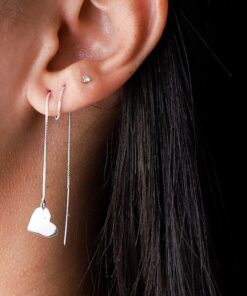 Mulher usando brinco de prata tipo coração