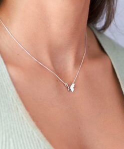 Modelo feminina jovem usando um colar de prata borboleta