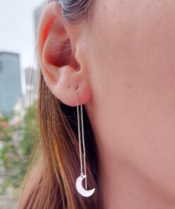 Mulher usando brinco de prata tipo meia lua