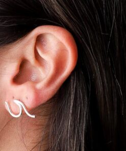 Brinco de prata tipo onda em uma orelha feminina