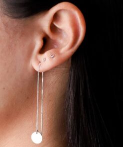 Mulher usando brinco de prata tipo estrela pequeno