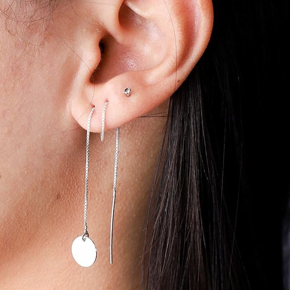 Mulher usando brinco de prata tipo circulo