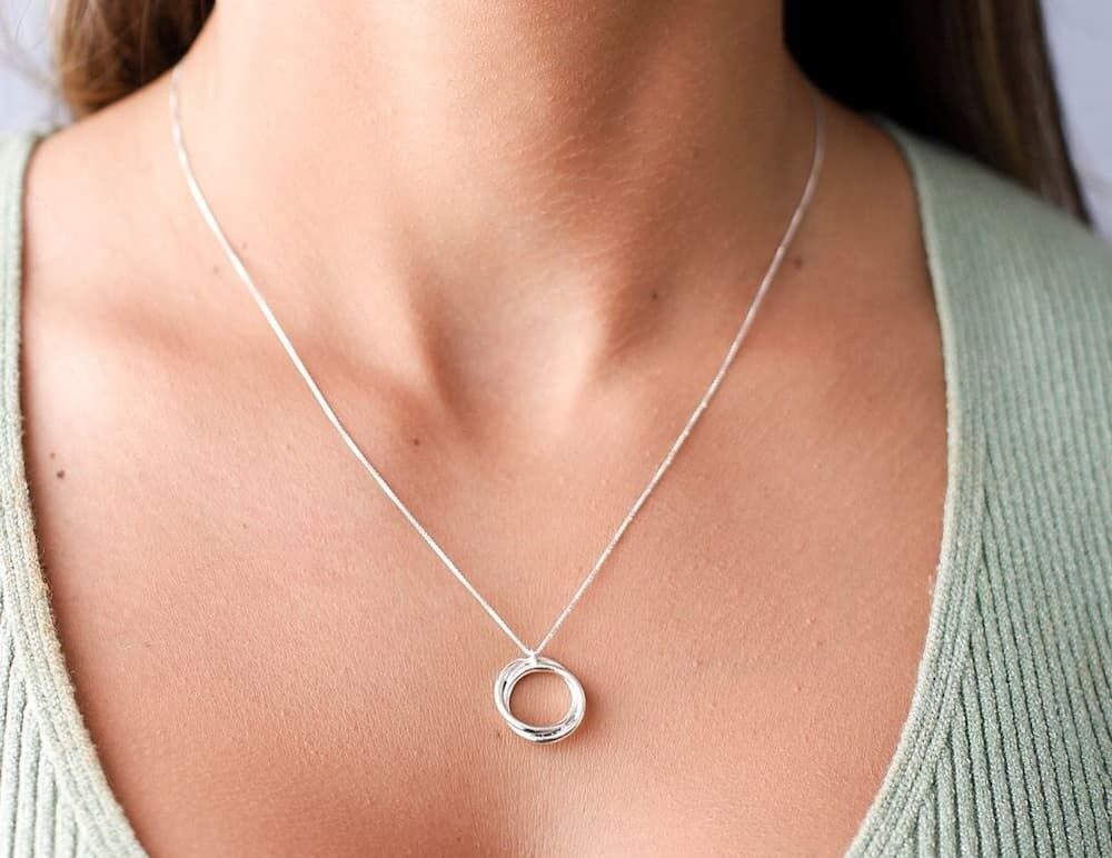 Mulher usando um colar de prata modelo Nó de Marinheiro