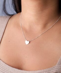 Mulher usando um colar de prata modelo Coração de angulo diferente