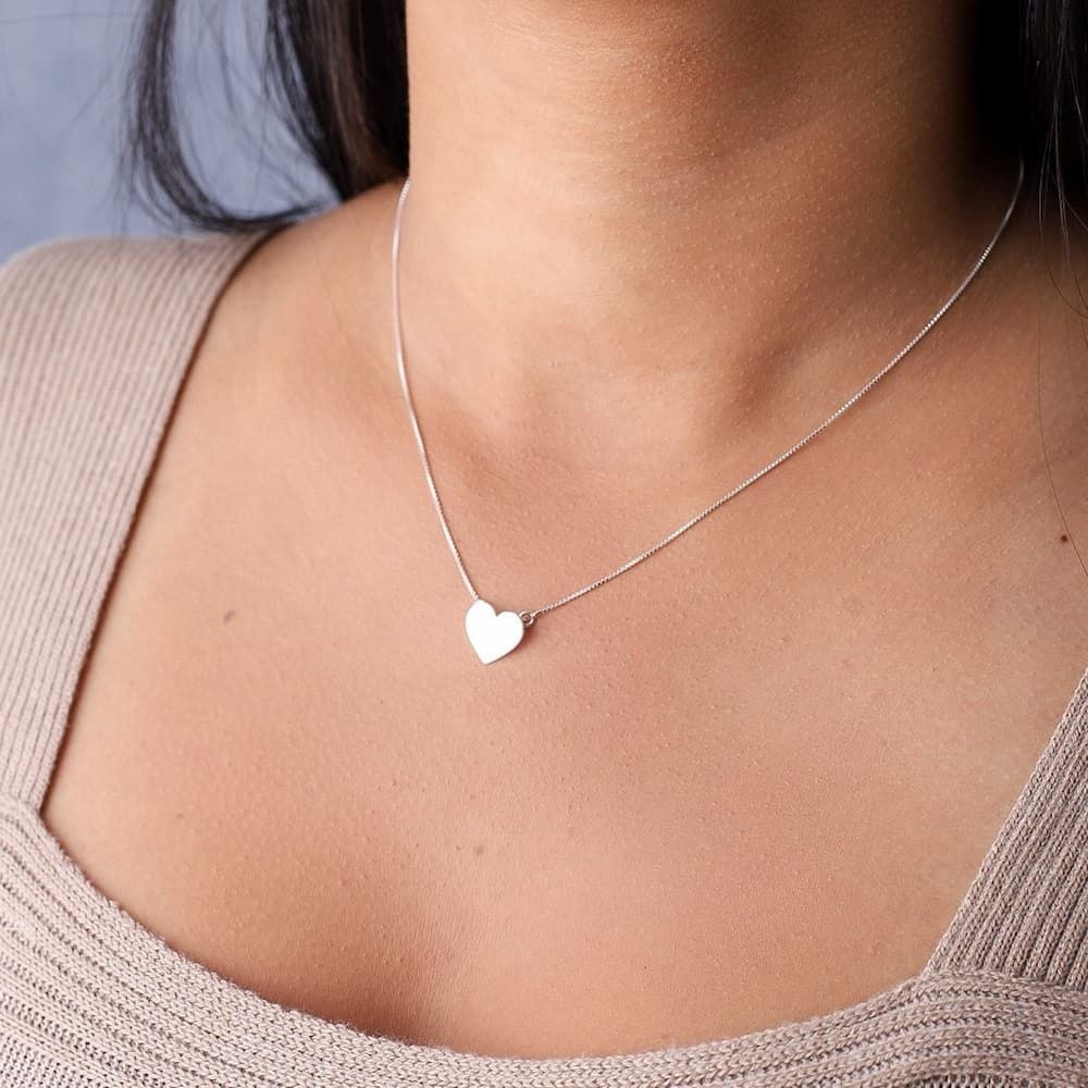 Mulher usando um colar de prata modelo Coração de angulo diferente
