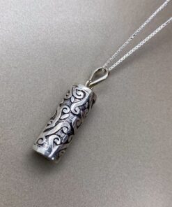 Pingente de prata em uma superfície lisa