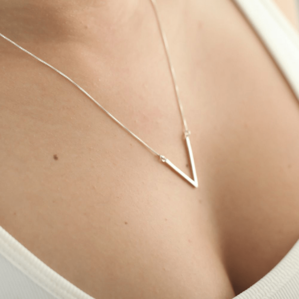 Modelo feminina jovem usando um colar V Pequeno