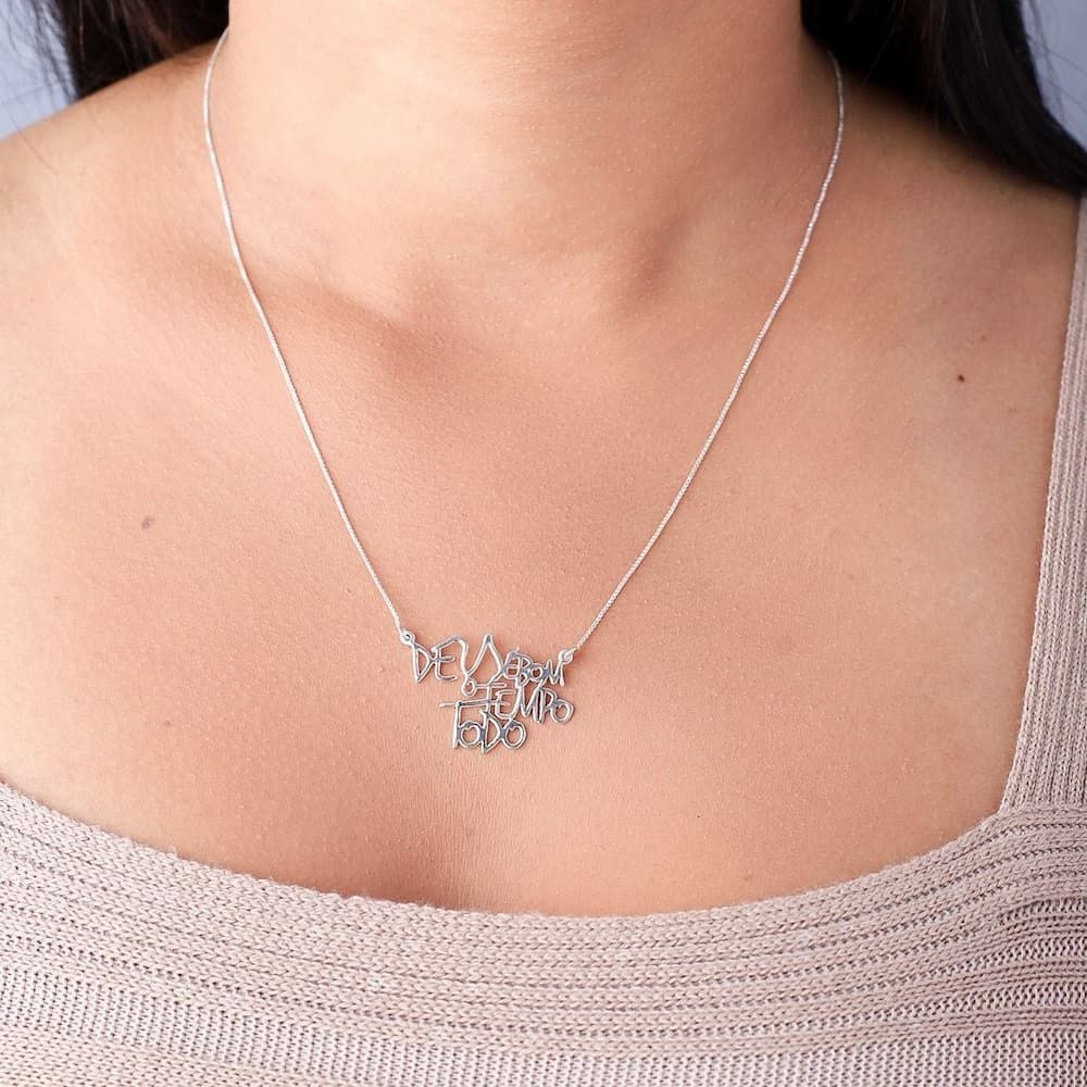 Moça jovem usando um colar Deus é Bom o Tempo Todo