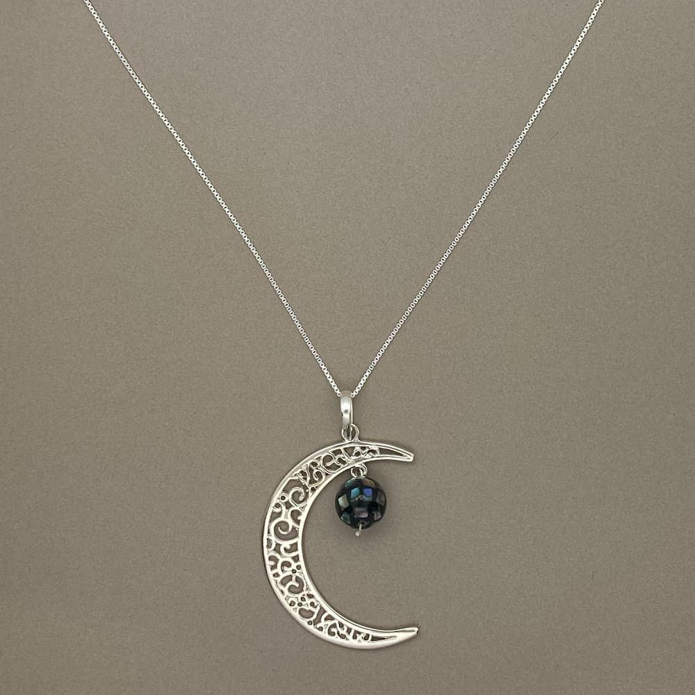 Colar Lua Globo Abalone sobre uma superfície lisa