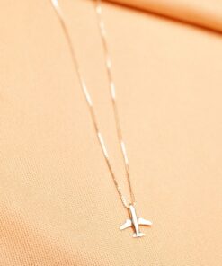 Foto do colar “Colar Aviãozinho”, acima de uma base de tecido