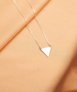 Foto do colar “Triangulo Mini”, acima de uma base de tecido
