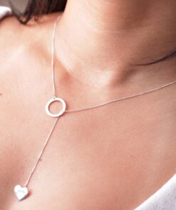 Modelo feminina de camisa branca usando uma Gravatinha circulo e coração