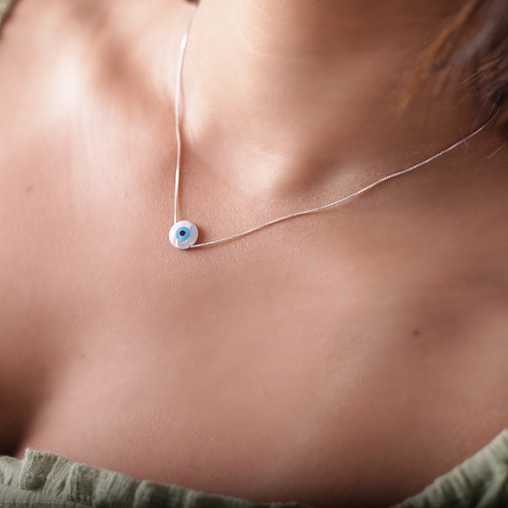 pescoço feminino com colar de prata olho grego