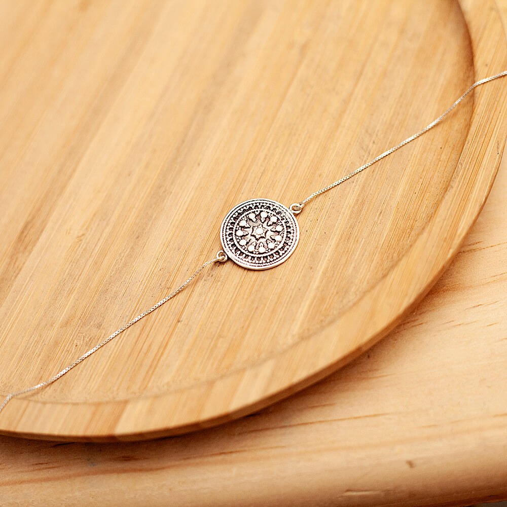 Foto da Pulseira Mandala acima de uma base de madeira rústica