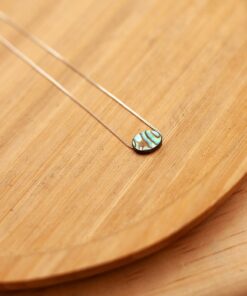 colar pedra abalone sobre prato de madeira