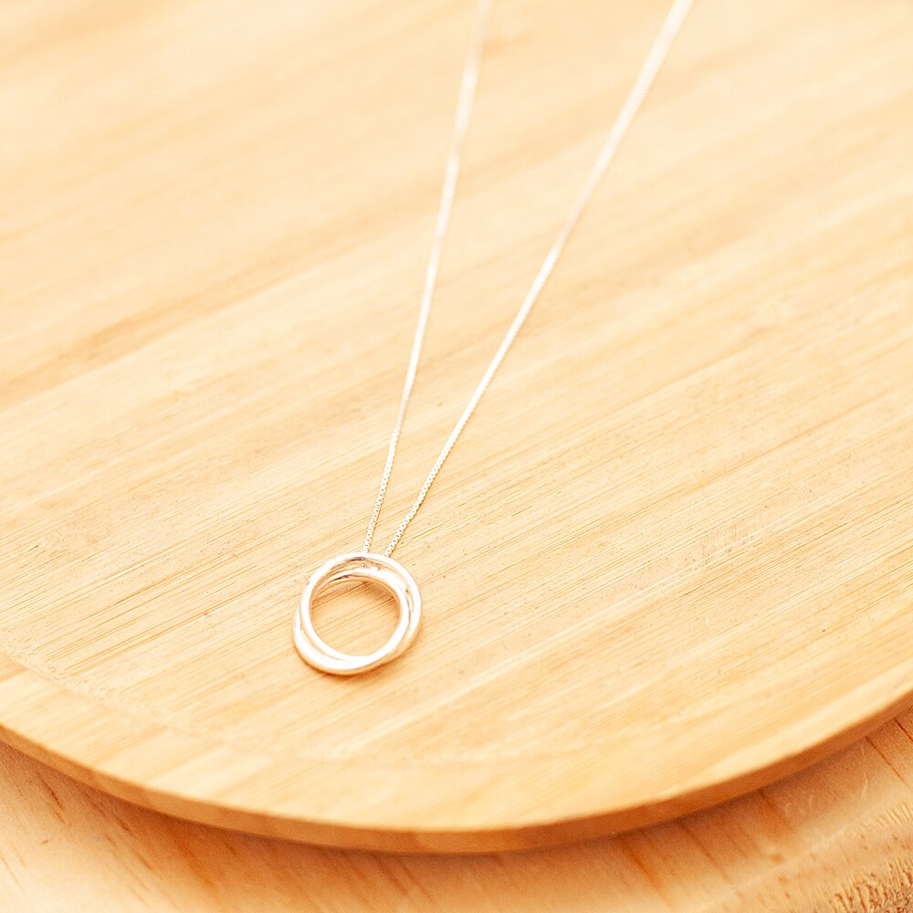 Colar de prata Nó de Marinheiro sobre uma superfície de madeira