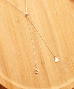 Gravatinha de corações em prata 925 sobre um prato de madeira