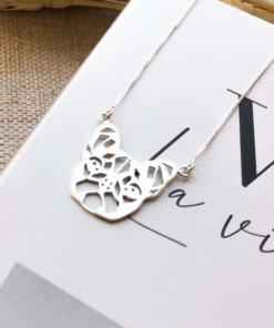 Colar Buldog em prata 925 em cima de um livro