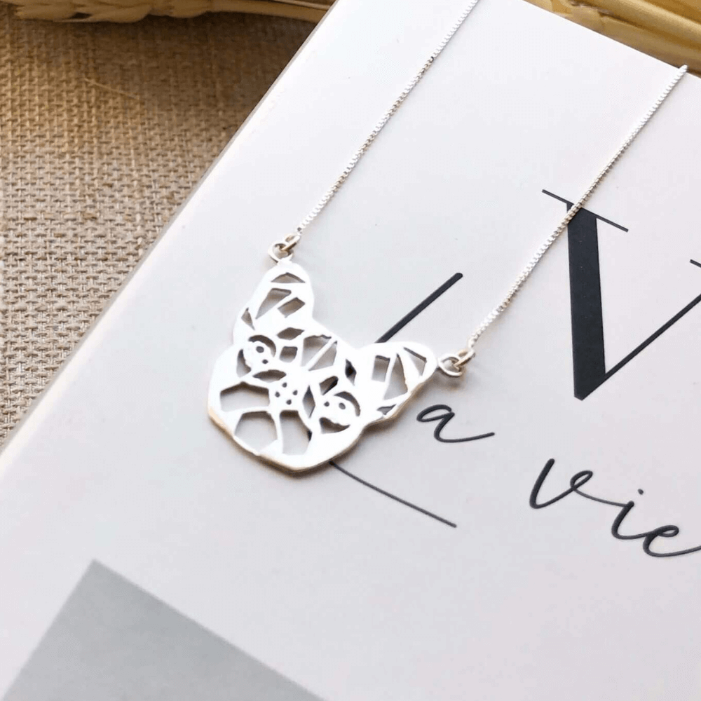 Colar Buldog em prata 925 em cima de um livro