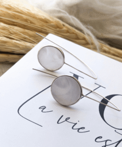 brinco gancho madre em cima de livro