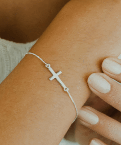 Pulseira cruz mini de prata 925 em braço feminino