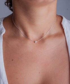 Modelo feminina jovem usando um colar bolinha