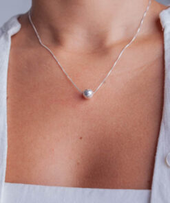 Modelo feminina de camiseta branca usando um Colar Bola Lisa