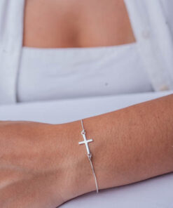 Pulseira cruz mini de prata 925 em braço feminino