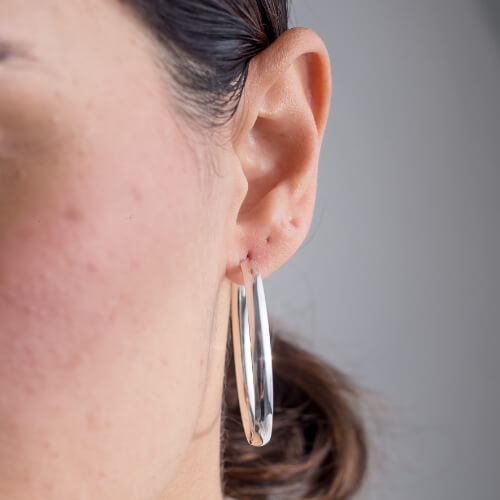 Modelo Feminina usando Argola Abaolada grande de prata 925