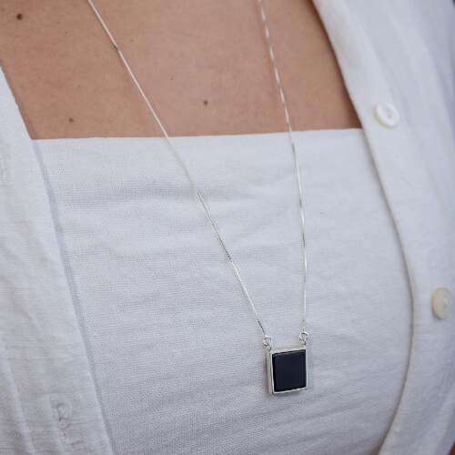 Modelo feminina usando Escapulario Olho de Tigre e Onix Quadrado de prata 925