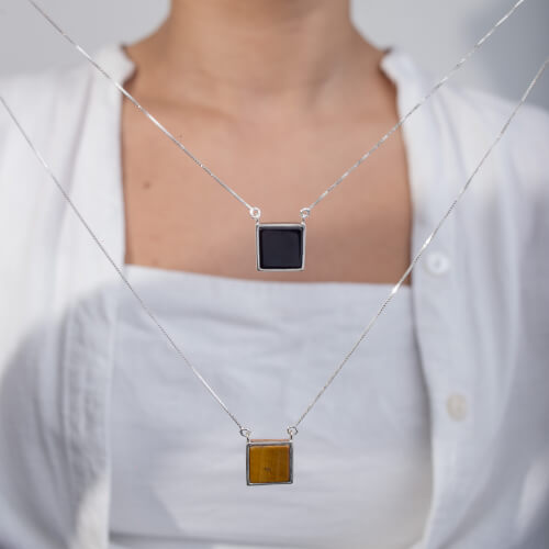 Modelo feminina usando Escapulario Olho de Tigre e Onix Quadrado de prata 925